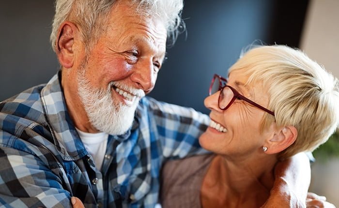 Happy romantic senior couple hugging and enjoying retirement at home copy